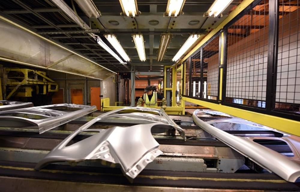 A member of Nissan's manufacturing staff inspects vehicle body sides as they leave the 5 000 tonne press in their Sunderland Plant in North East England.