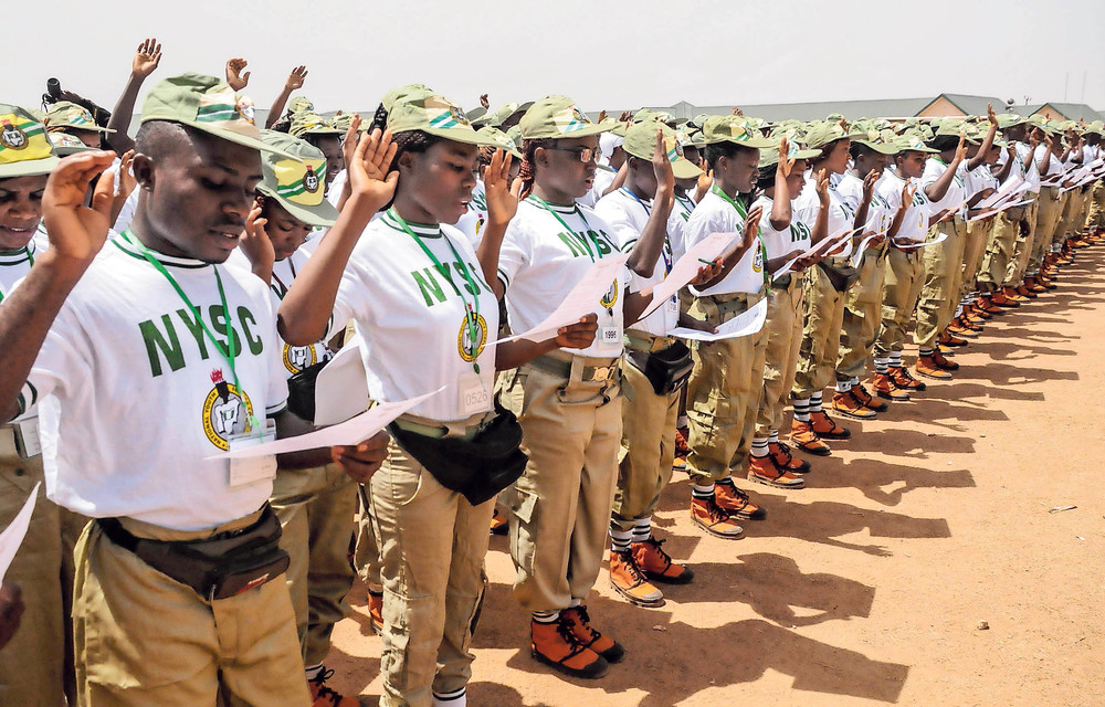 A batch of corps members take an oath of allegiance during their swearing-in ceremony in Jos