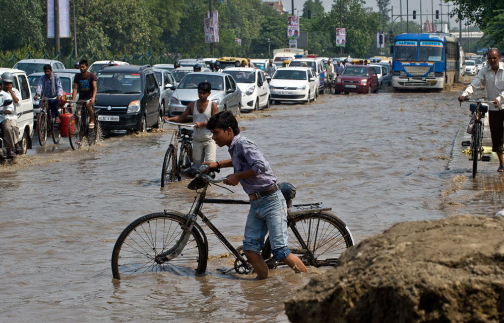 Vehicles pass through a water-logged road as the waters of the Yamuna River rise in New Delhi.