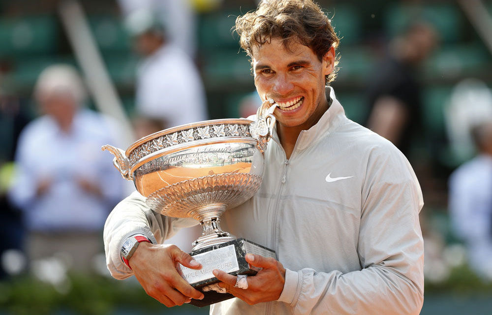 Rafael Nadal bites the trophy as he poses during the ceremony after defeating Novak Djokovic.