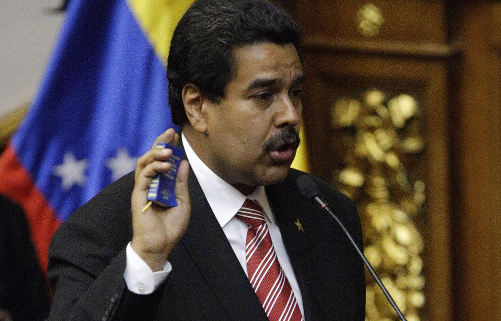 Nicolas Maduro holds a copy of Venezuela's Constitution as he is sworn in as Venezuela's acting president in Caracas on March 8.