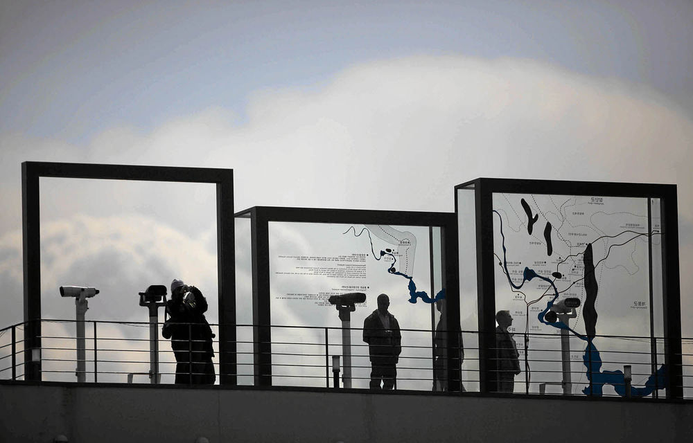 Visitors in Paju look to the north behind a map showing the demilitarised zone that divides the two Koreas. The countries have been separated since 1950.