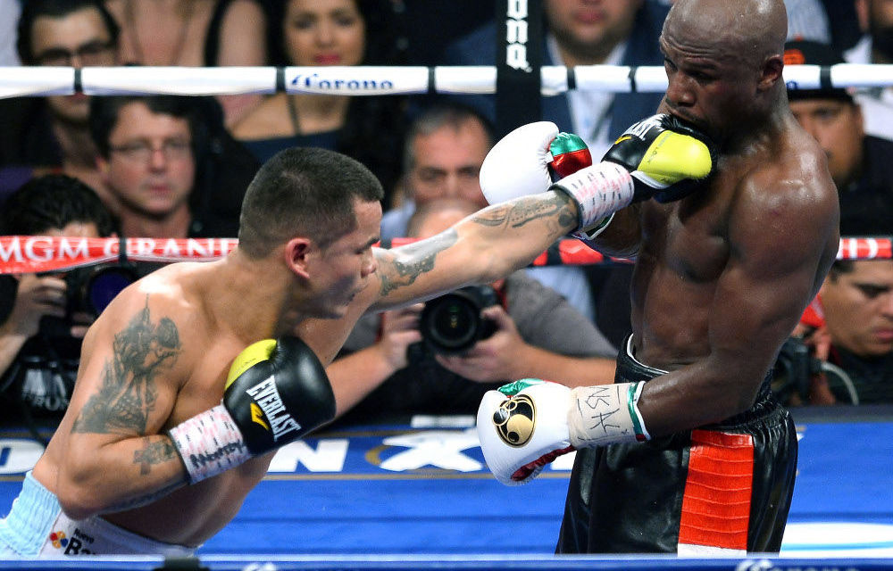 Mayweather stays unbeaten, but not without bruises