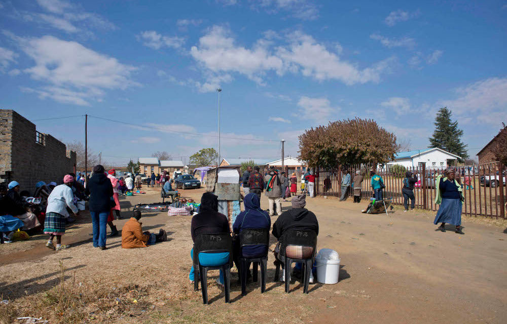 Three women who work for a loan shark wait for grant recipients at Thembalihle township in the Free State to repay the loans they have taken.