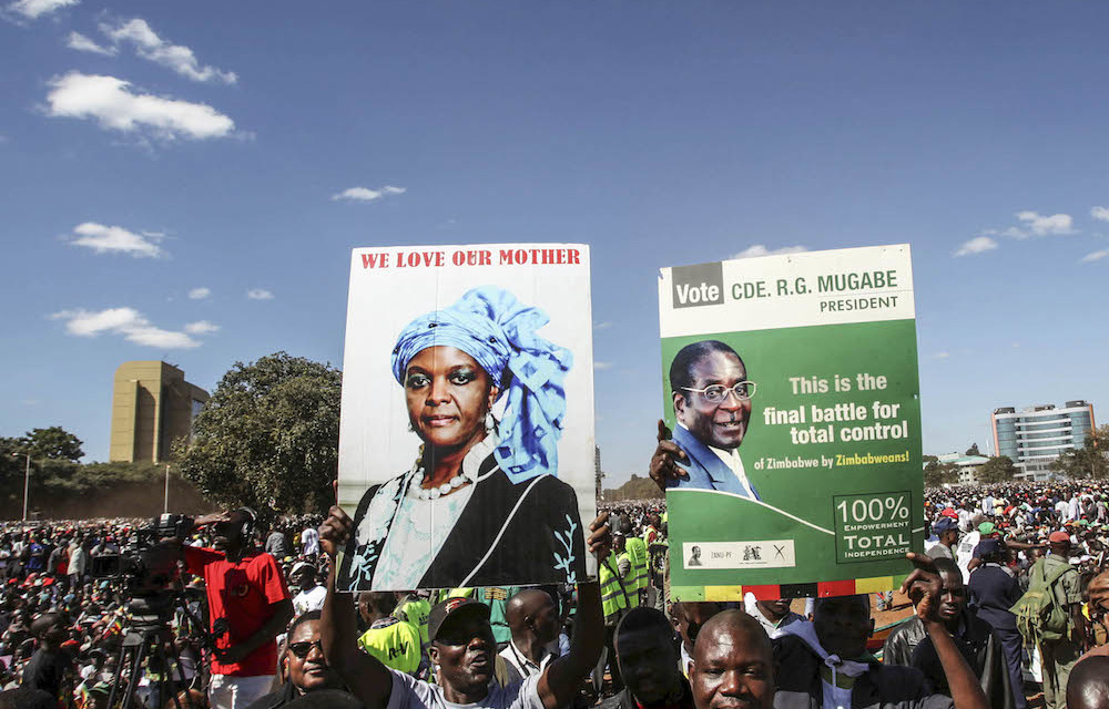 Youths from the ruling Zanu-PF party hold portraits of President Robert Mugabe and his wife Grace during the "One Million Man March"