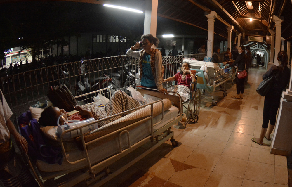 Hospital patients are moved outside after a large earthquake struck on the nearby island of Lombok