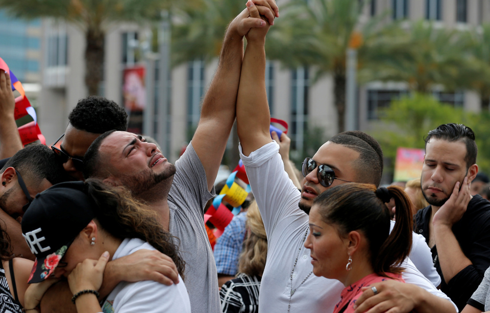 Mourners grieve at a vigil for the victims of the shooting at the Pulse gay nightclub in Orlando