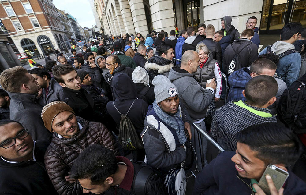 Customers queue outside an Apple store prior to the sale of the iPhone 6S in London