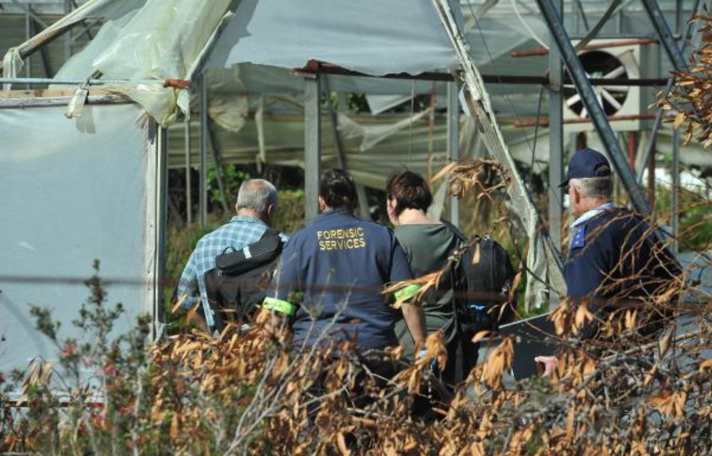 Plot thickens: Police and forensic investigators at the crime scene where Mark Minnie was found dead on Monday.