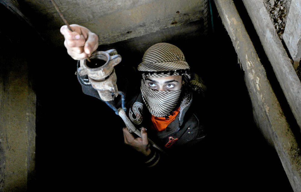 A Palestinian smuggler works inside a tunnel beneath the