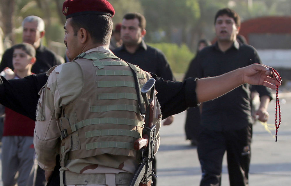 A soldier mans a checkpoint in Baghdad's Kadhimiya district on October 6 as Shi'ite pilgrims walk to a shrine to commemorate the death of Imam Mohammed al-Jawad.