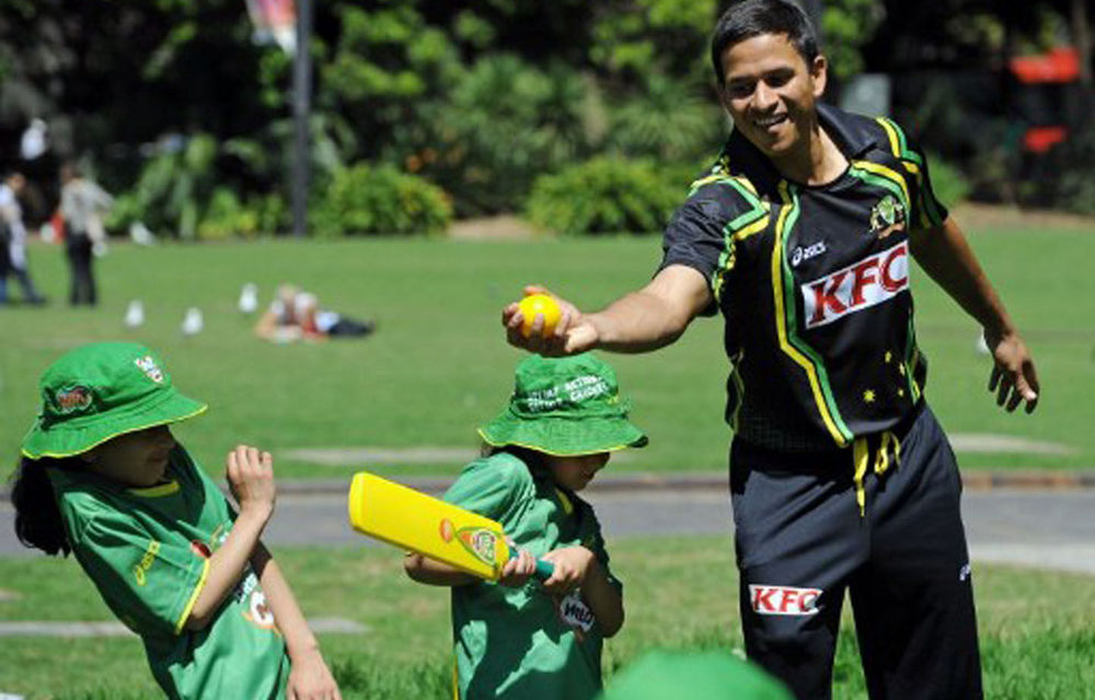 Australian cricketer Usman Khawaja joins in an activity with junior cricketers during the launch of the Australian cricket season.