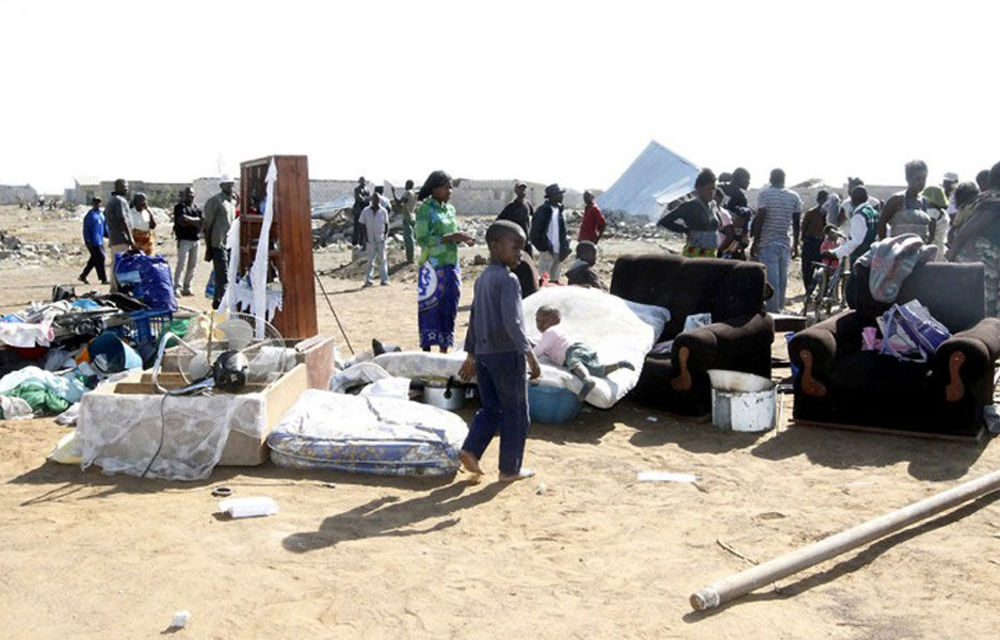 Zambian residents stand among their household belongings in the Chinika township oin Lusaka. Hundreds of Zambians faced a night on the streets