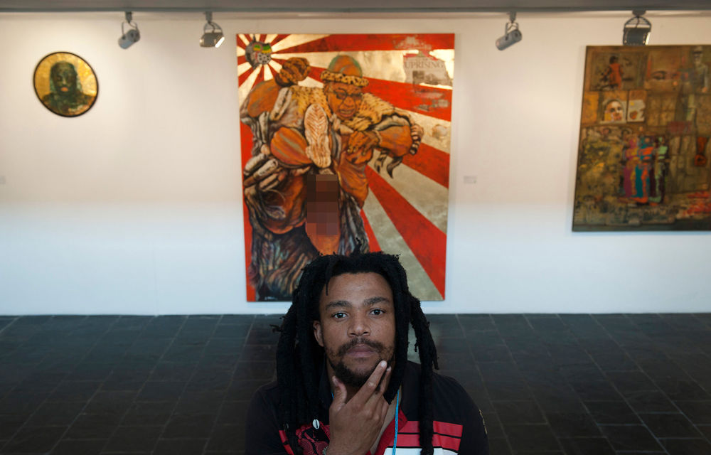 Artist Ayanda Mabulu poses with his controversial painting "Umshini Wam - Weapon of Mass Destruction" at the AVA Gallery in Cape Town.