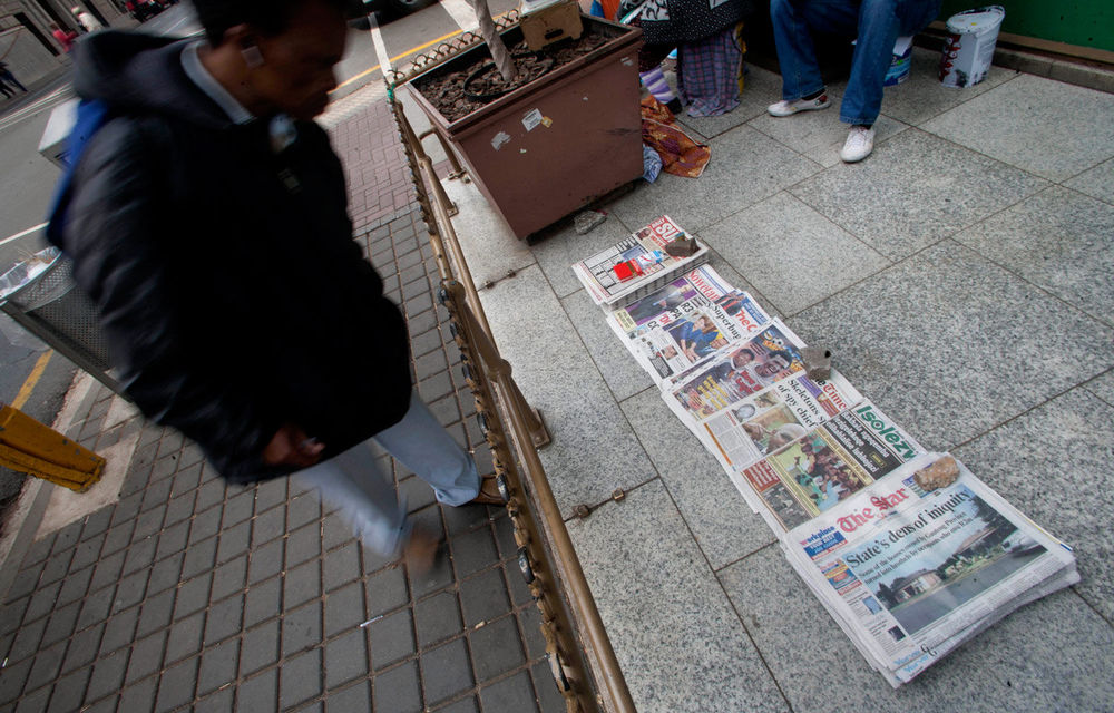 A man browses the morning newspapers.