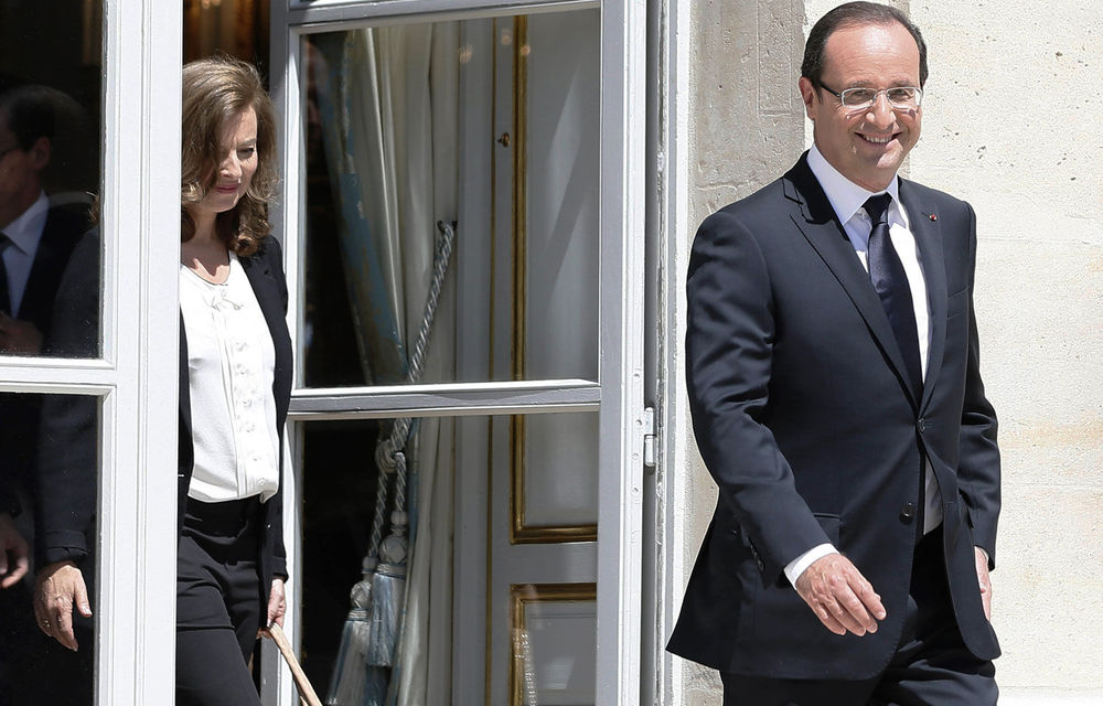 French President Francois Hollande arrives with his companion Valerie Trierweiler as they walk into the gardens of the Elysee Palace