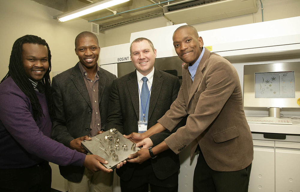 CRPM staff members exhibiting titanium manufactured parts.