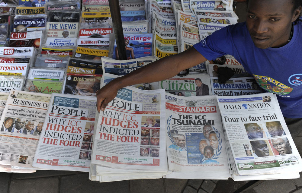 A newspaper vendor sells the day's papers carrying in the headlines photos of four Kenyans to face charges of crimes against humanity before the International Criminal Court