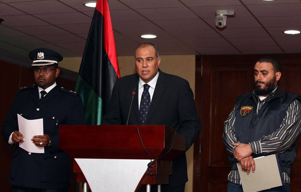 Libyan government spokesperson Nasser al-Manaa speaks as Salem Ahbaj