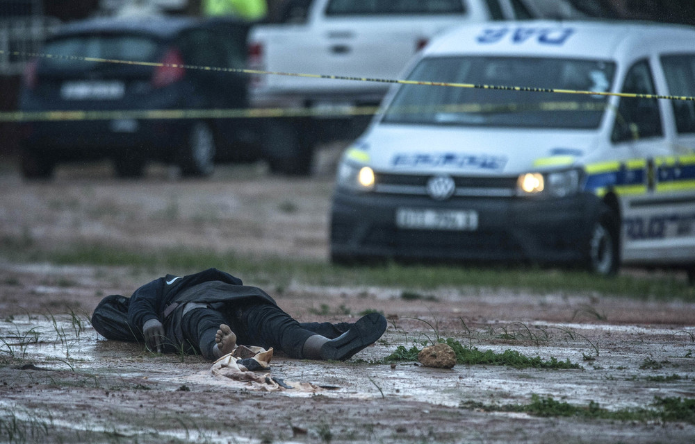 Forensic investigators and pathologists examine the crime scene and the body of murdered suspect after he was reportedly shot and killed by police for stabbing two worshippers at a mosque on June 14 2018