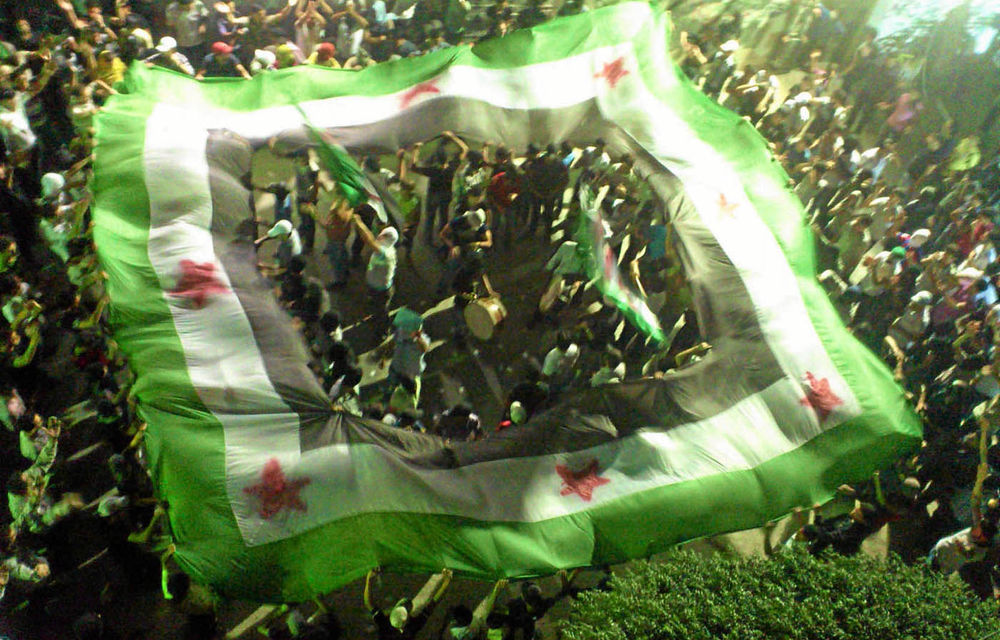 Protesters wave pre-Ba’ath Syrian flags during an anti-regime demonstration in Kfar Sousa.