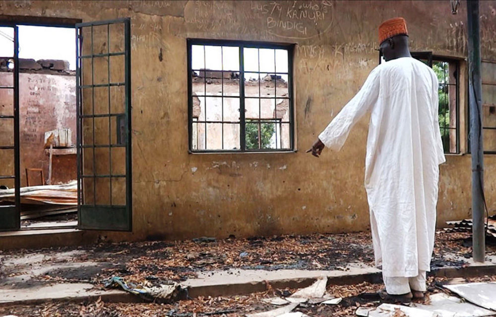 A teacher inspects a burnt school hostel at the Government Secondary School of Mamudo in north-east Nigeria where Boko Haram gunmen launched attacks.