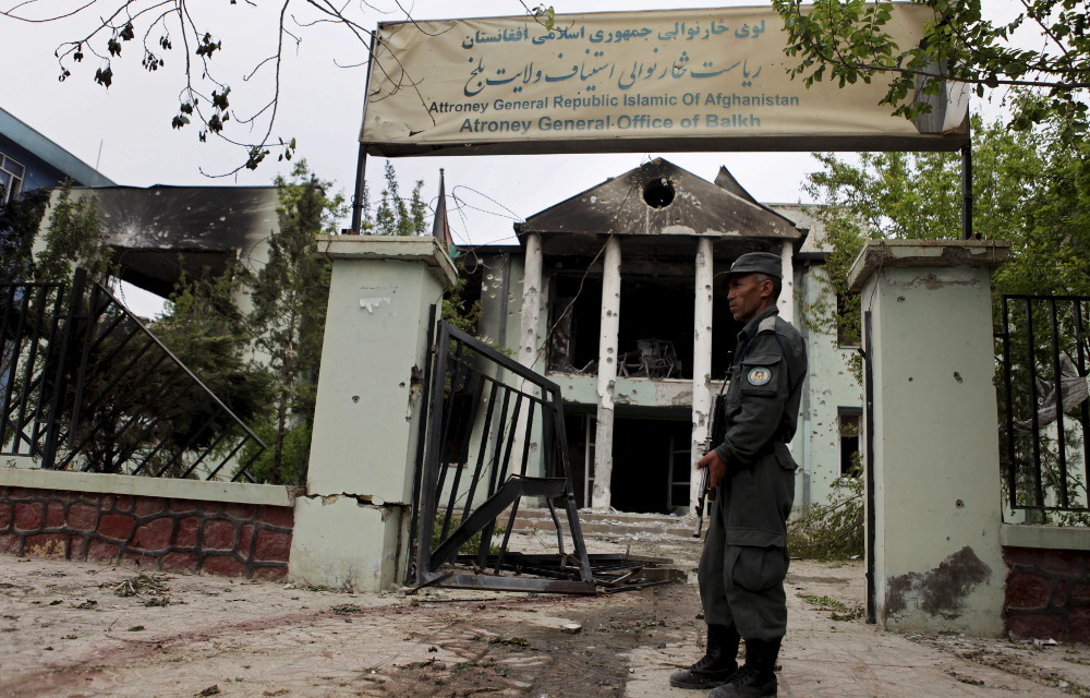 An Afghan police officer guards the Mazar-i-Sharif court the Taliban attacked on April 10