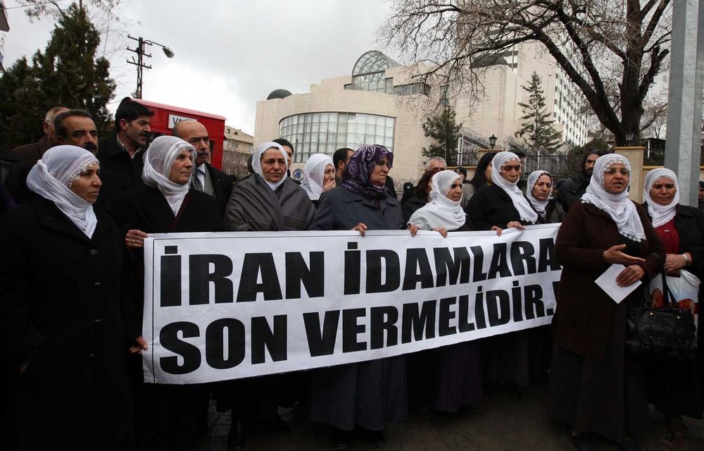 Kurdish women carry a banner that reads 'Iran should end executions' as they protest against the Iranian regime outside the Iran embassy in Ankara