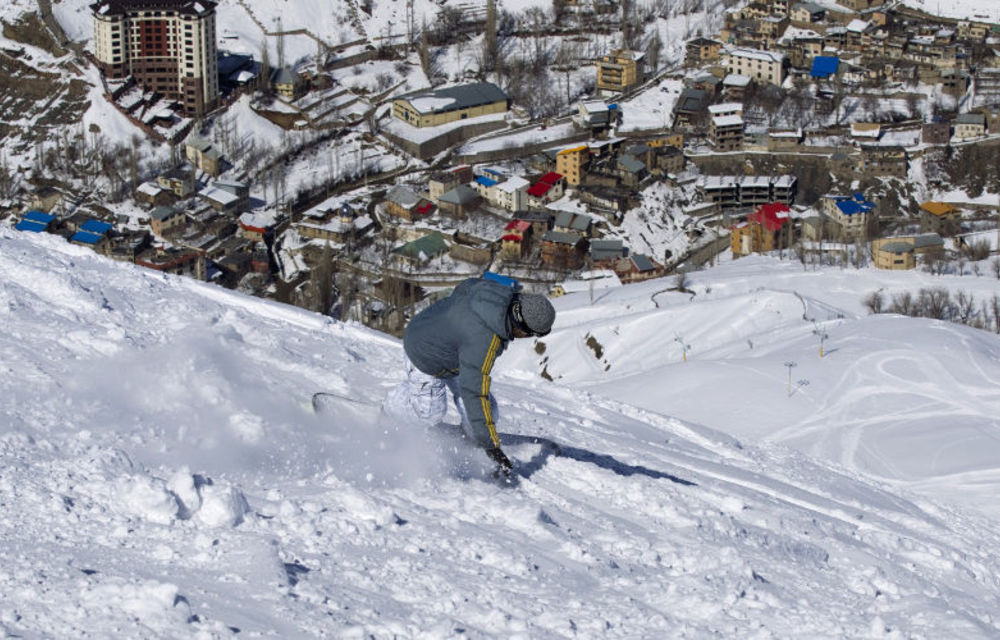 From sea to snow: Snowboarding at Iran's Shemshak ski resort and calm waters off Kish Island.