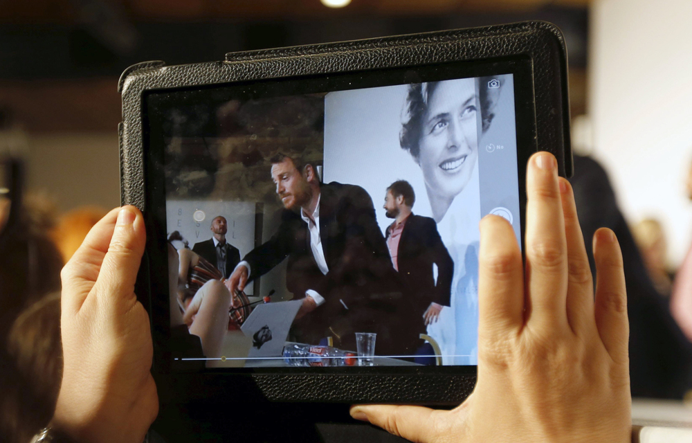 A journalist takes a picture with a tablet device