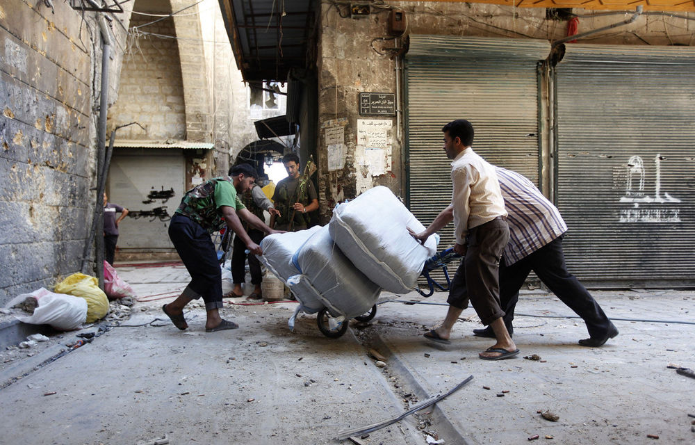 A file photograph from September 24 shows a Free Syrian Army fighter helping traders at the souk in Aleppo.