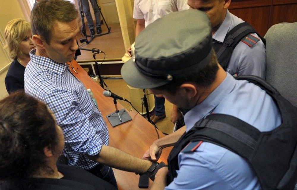 A police officer handcuffs Russia's top opposition leader Alexei Navalny in the courtroom in Kirov on July 18 2013.