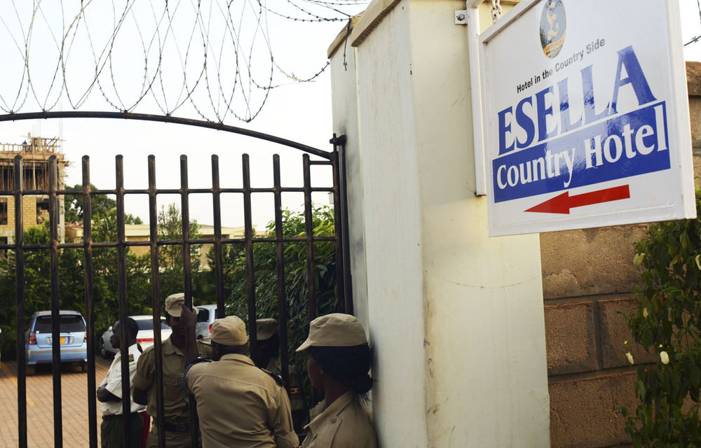 Ugandan police officers stay at the entrance of the Esella Country Hotel after police raided a gay rights workshop which was taking place in the hotel