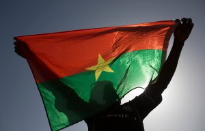 A pro-democracy protester holds up a Burkina Faso flag at Place de la Nation in capital city Ouagadougou.