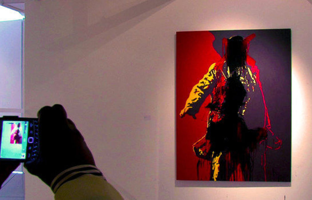 A visitor photographs a painting of President Jacob Zuma at the Goodman Gallery in Johannesburg on May 18.