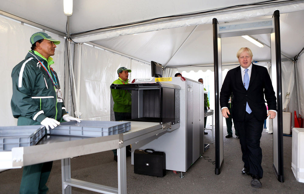 Mayor of London Boris Johnson goes through a security procedure as he visits the London 2012 Olympic Athletes Village.