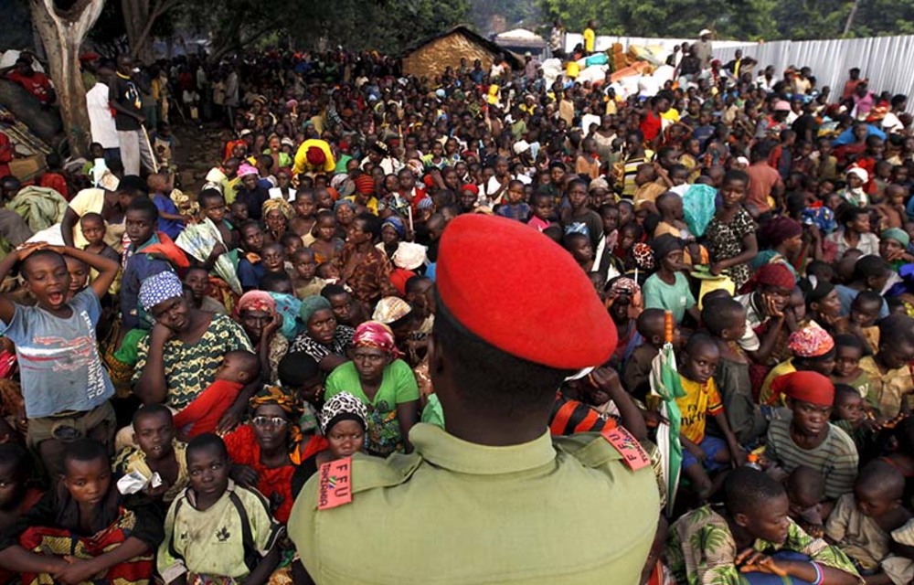 A Tanzanian policeman watches over Burundian refugees on the shores of Lake Tanganyika in Western Tanzania.