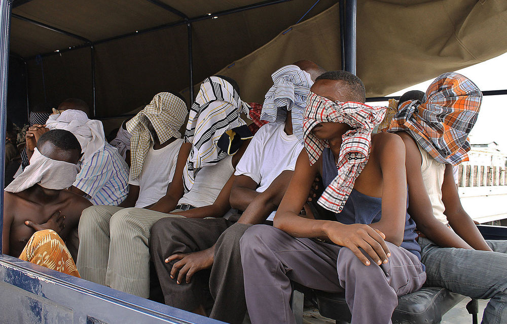 Suspected al-Shabab fighters sit on a tuck after being rounded up by Somalia's troops during an operation at Elasha Biyaha.