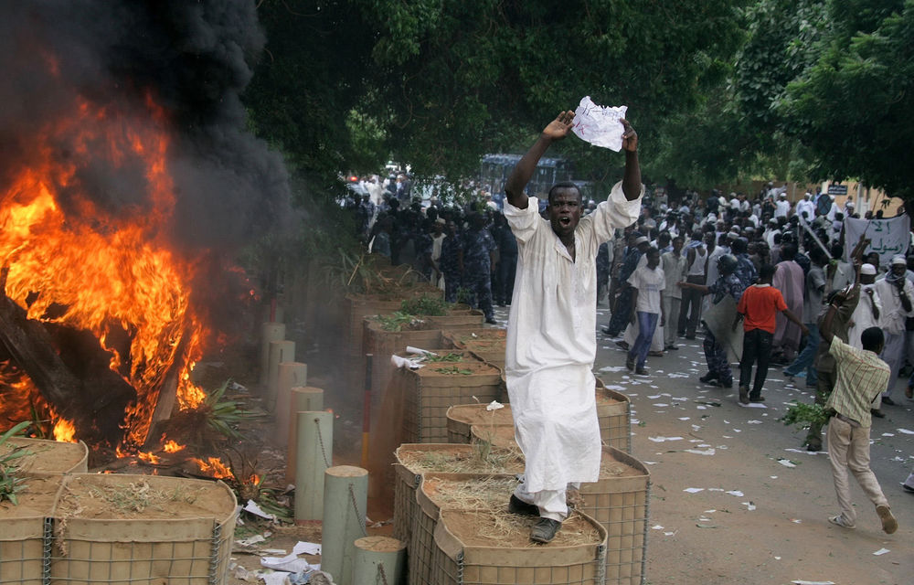 A Sudanese demonstrator shouts slogans as policemen try to disperse protesters after they torched the German embassy in Khartoum during a demonstration against a low-budget film mocking Islam.