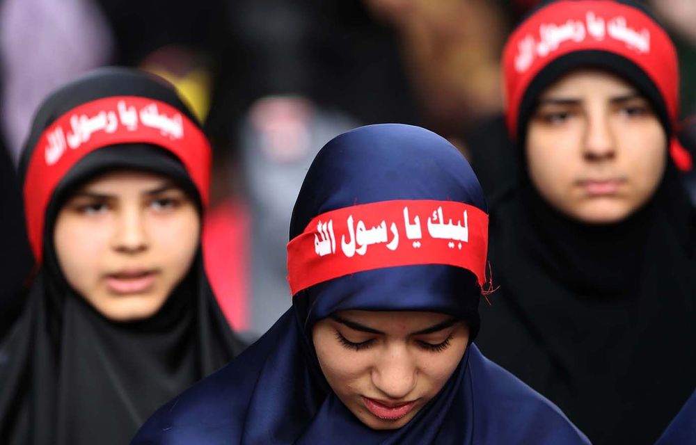 Women wear headbands reading 'at your service God's prophet' at a rally denouncing the film 'Innocence of Muslims'.