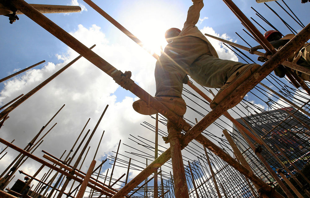 A construction worker walks on scaffolding along the Nairobi-Thika highway project in Nairobi.