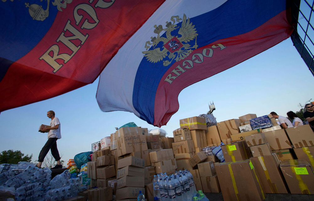 A man carries a food box where people are collecting supplies to be sent to Krymsk for flood victims