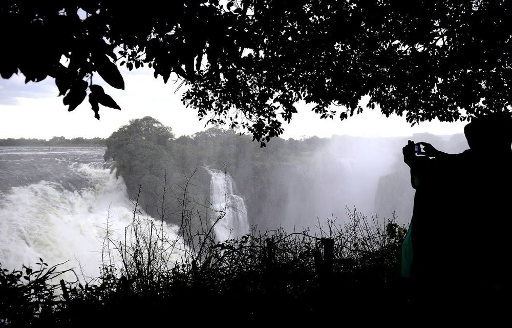 A tourist takes a picture of the Victoria Falls in Zimbabwe.