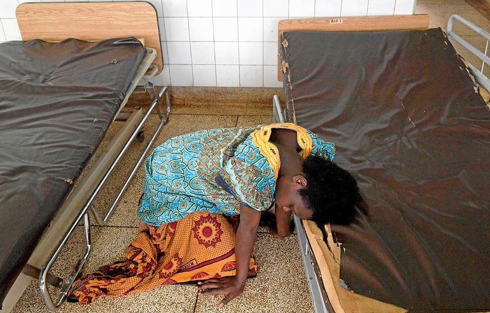 Helpless: A woman waits to be assisted by a midwife in the delivery room of a hospital in Uganda. Ugandan health workers tend to move abroad because there are no jobs at home.