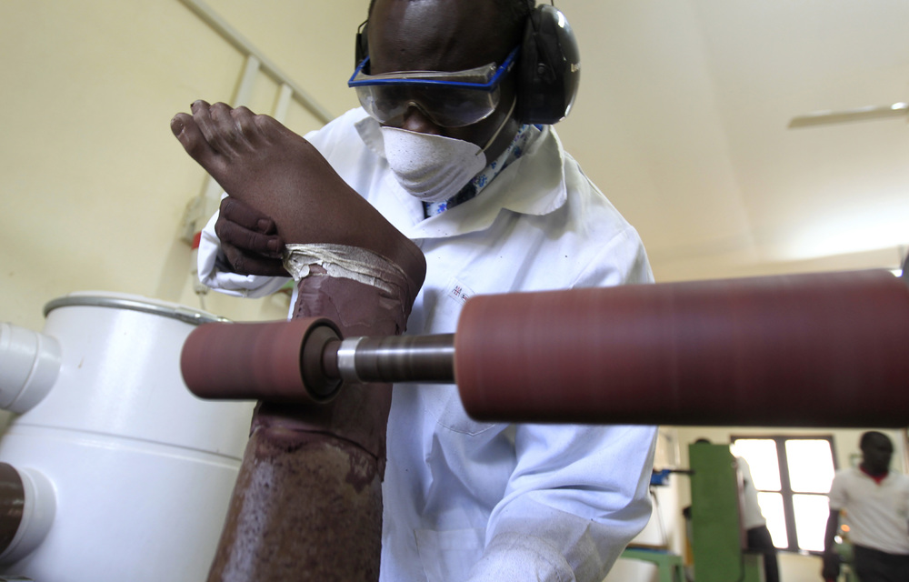 In the factory: Plaster is slapped on models of legs whirring on machines as workers shape them and then slather them in dark brown plastic.