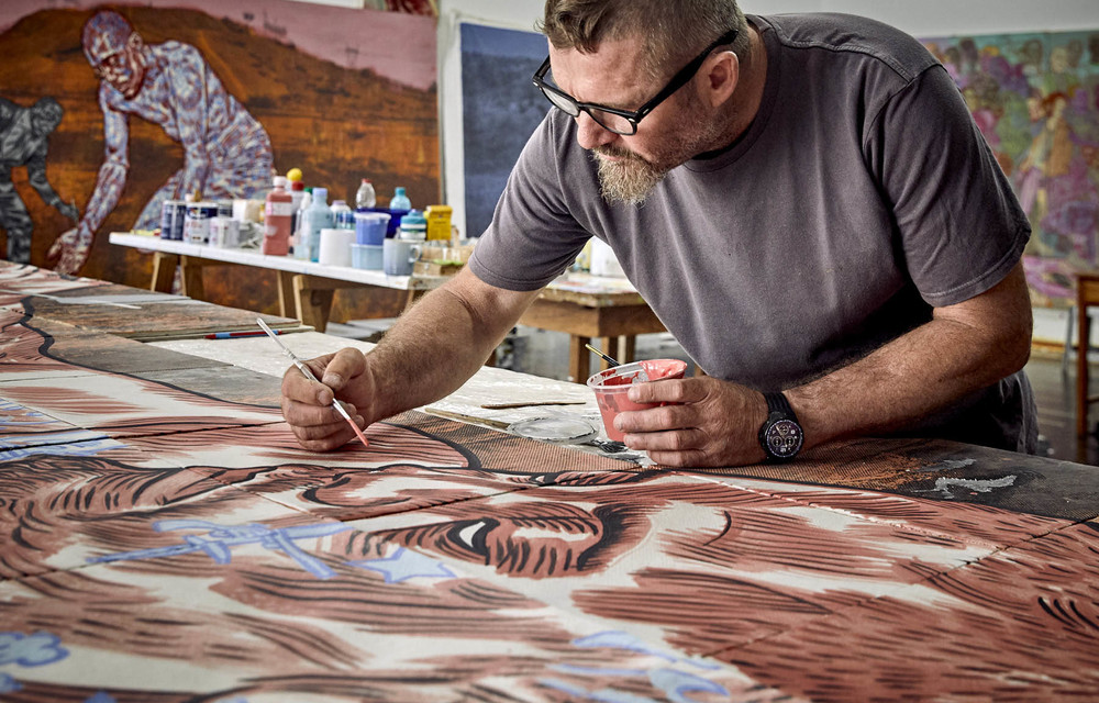 At work: Conrad Botes uses photographs of Marikana as a backdrop to his paintings. Photo: Jan Verboom