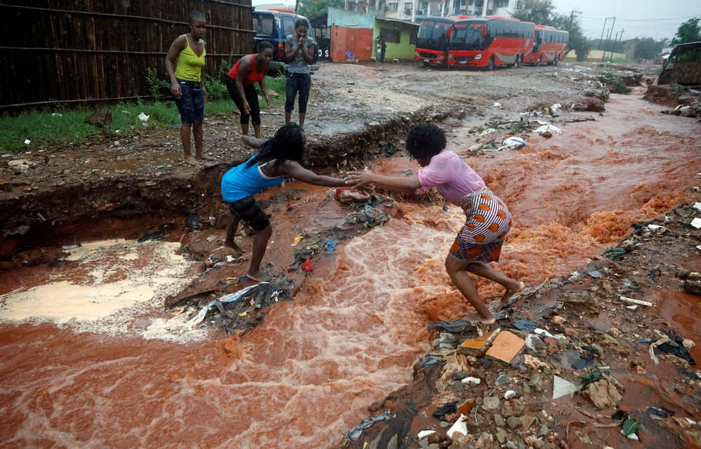 A woman crosses a flooded street in the aftermath of Cyclone Kenneth in Pemba.