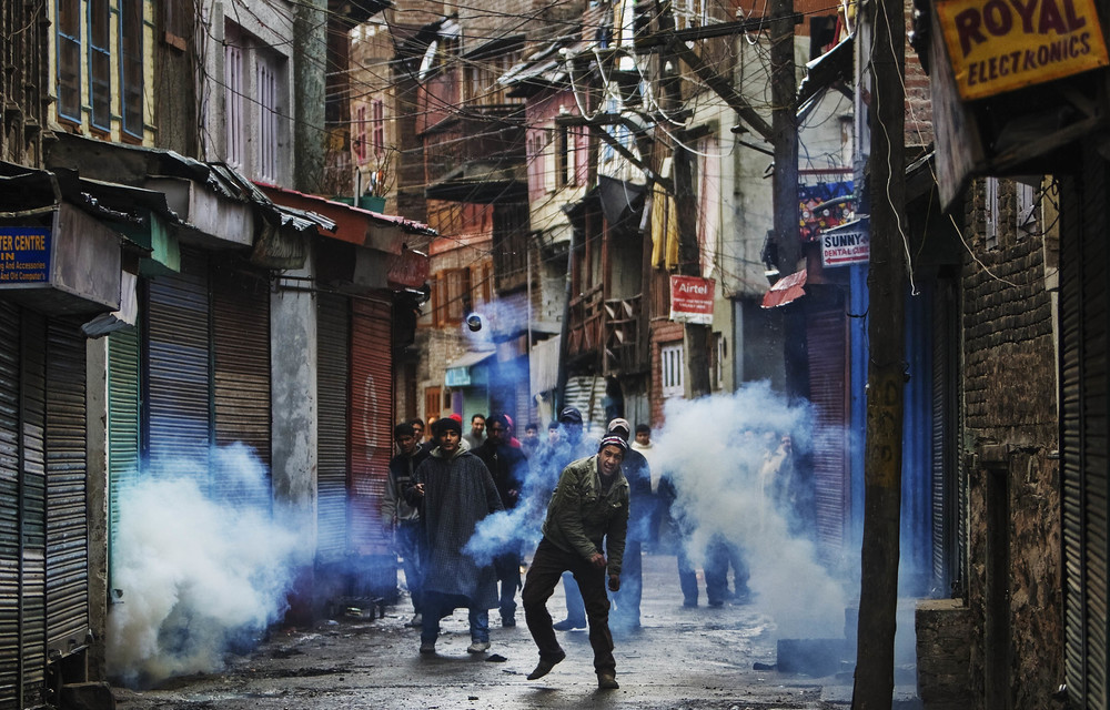 Outrage: A protester throws back a teargas canister shot by Indian police in Srinagar