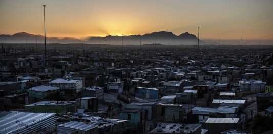 Nightfall: As the sun sets over Table Mountain the informal settlements become dark because homes have no electricity.