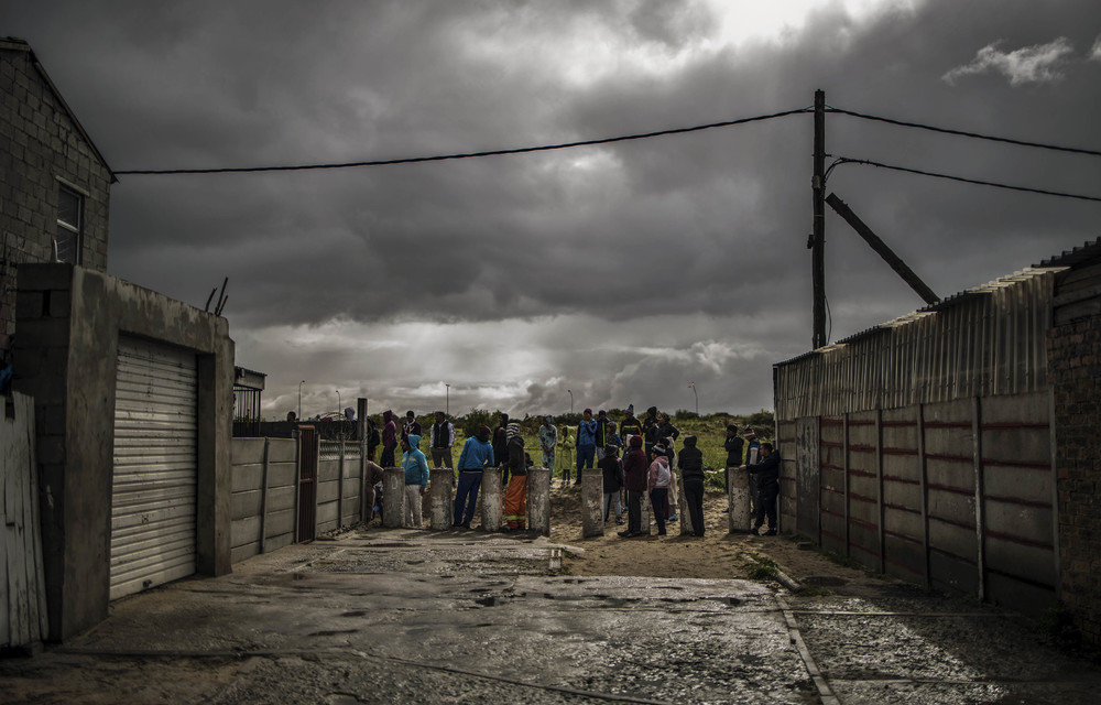 Protest nation: Residents gather to observe anti-riot policemen during a service delivery protest in the Cape Flats. Citizens are rejecting formal politics and elections in favour of the streets.